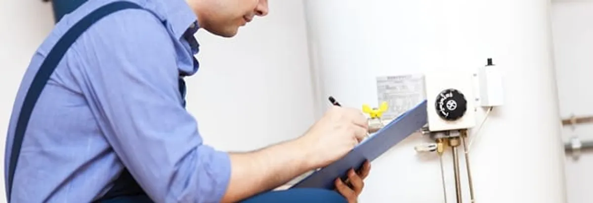 Water heater repair technician inspecting the unit and recording service notes in Boulder, CO